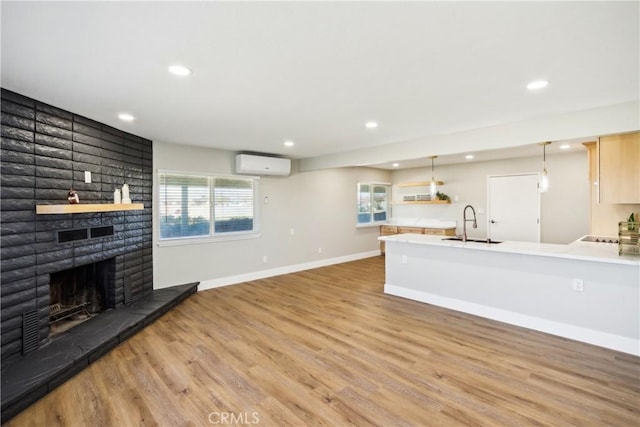 16621 Verano St, Hesperia, CA 92345 - unfurnished living room featuring a wall mounted air conditioner, recessed lighting, wood finished floors, a brick fireplace, and healthy amount of natural light