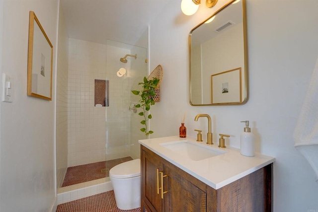 bathroom with toilet, visible vents, tiled shower, and vanity