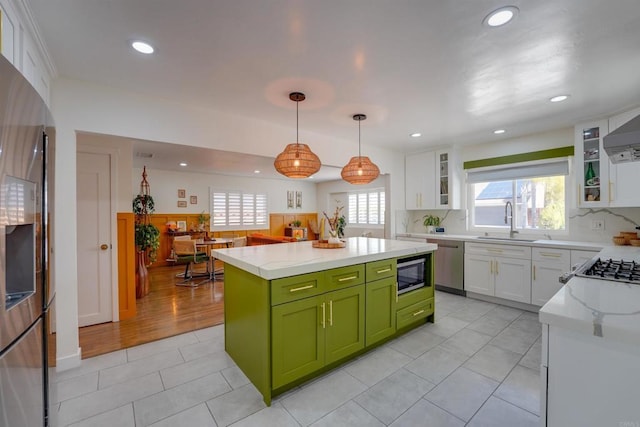 kitchen featuring a sink, green cabinets, a center island, white cabinetry, and appliances with stainless steel finishes