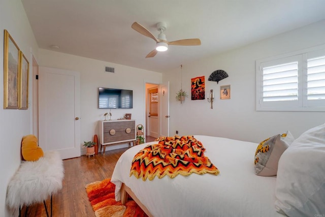 bedroom with wood finished floors, ceiling fan, and visible vents