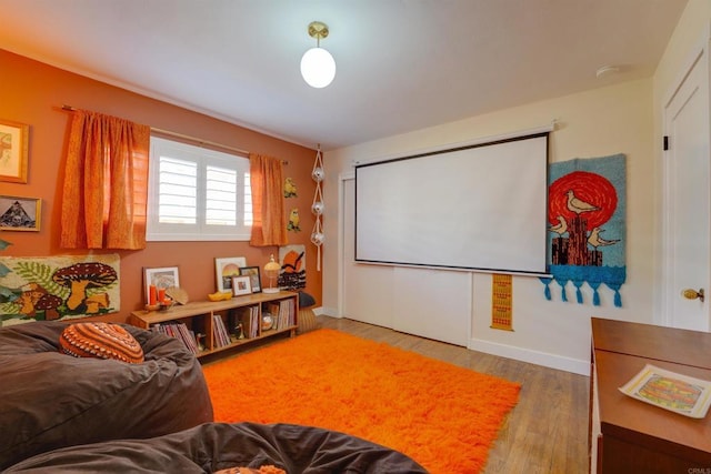 home theater room with wood finished floors and baseboards
