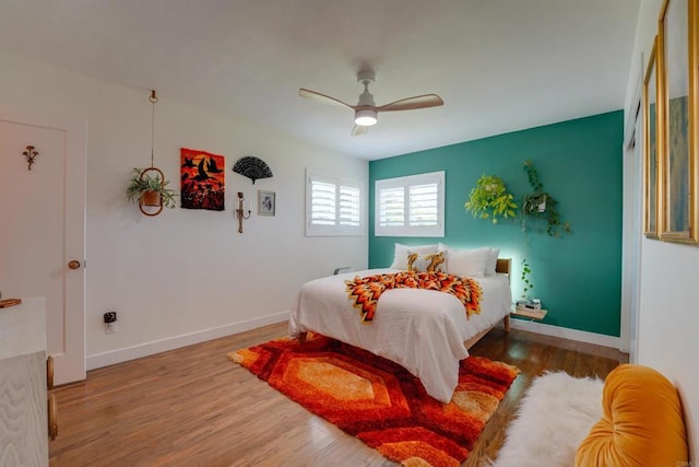 bedroom featuring wood finished floors, ceiling fan, and baseboards