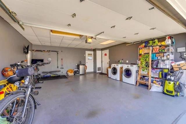 garage featuring visible vents, a garage door opener, and washing machine and clothes dryer