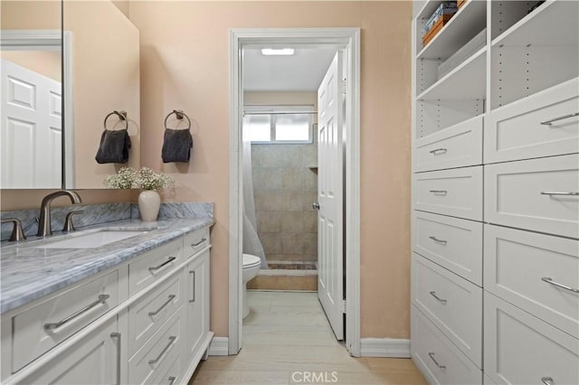 full bath with a shower stall, baseboards, toilet, vanity, and marble finish floor