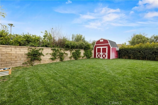 view of yard featuring an outbuilding, a shed, and a fenced backyard
