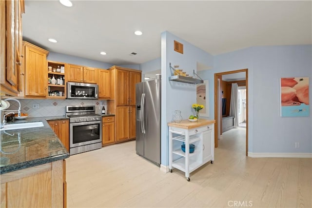 kitchen with a sink, open shelves, light wood-type flooring, backsplash, and appliances with stainless steel finishes