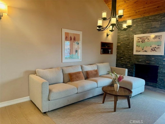 living room featuring a chandelier, baseboards, a fireplace, wood finished floors, and high vaulted ceiling