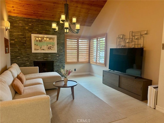 living room featuring wood finished floors, an inviting chandelier, wood ceiling, a stone fireplace, and baseboards