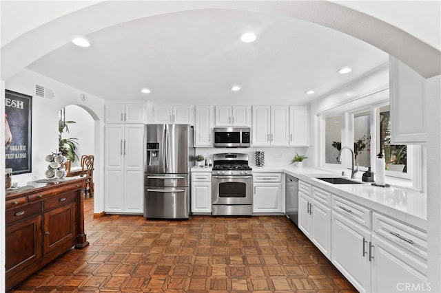 27955 Gallina, Mission Viejo, CA 92692 - kitchen with appliances with stainless steel finishes, arched walkways, white cabinets, light countertops, and recessed lighting
