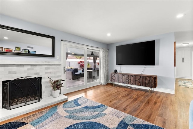 16680 Cedar Cir, Fountain Valley, CA 92708 - living room with wood finished floors, recessed lighting, a fireplace with raised hearth, and baseboards