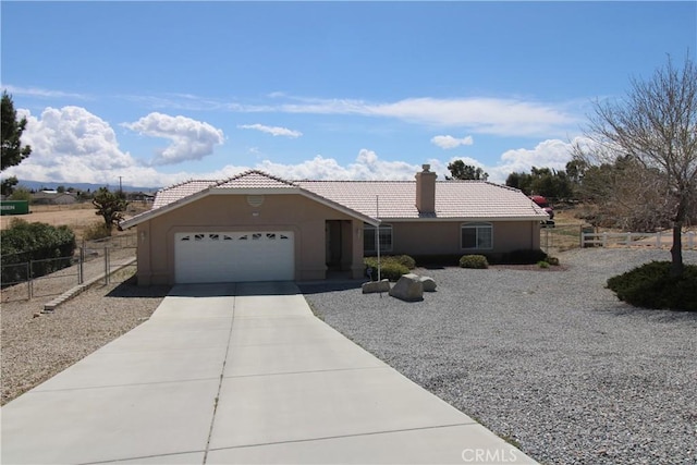 17255 Donert St, Hesperia, CA 92345 - ranch-style house featuring concrete driveway, stucco siding, an attached garage, a tiled roof, and fence