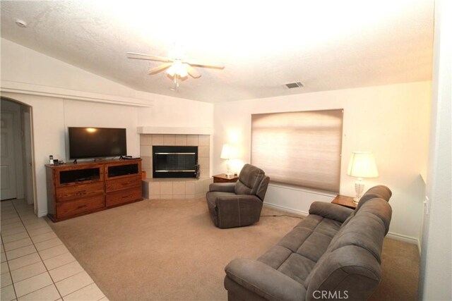 17255 Donert St, Hesperia, CA 92345 - carpeted living area with vaulted ceiling, tile patterned flooring, visible vents, ceiling fan, and a tile fireplace
