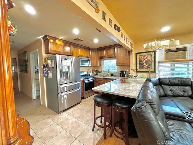238 Kellog Ave, Fullerton, CA 92833 - kitchen featuring appliances with stainless steel finishes, a peninsula, light tile patterned flooring, open floor plan, and brown cabinets