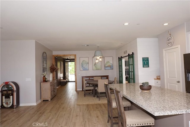 34539 Velvetleaf St, Winchester, CA 92596 - dining area with a barn door, light wood-type flooring, recessed lighting, and baseboards