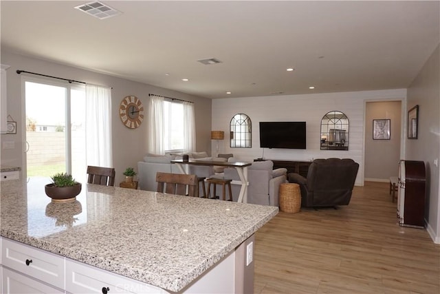 34539 Velvetleaf St, Winchester, CA 92596 - kitchen featuring white cabinets, light wood-style flooring, light stone counters, open floor plan, and recessed lighting