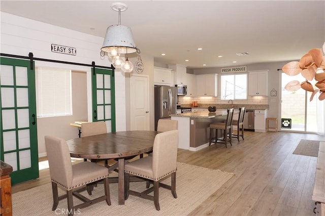 34539 Velvetleaf St, Winchester, CA 92596 - dining space featuring a barn door, light wood-style flooring, and recessed lighting
