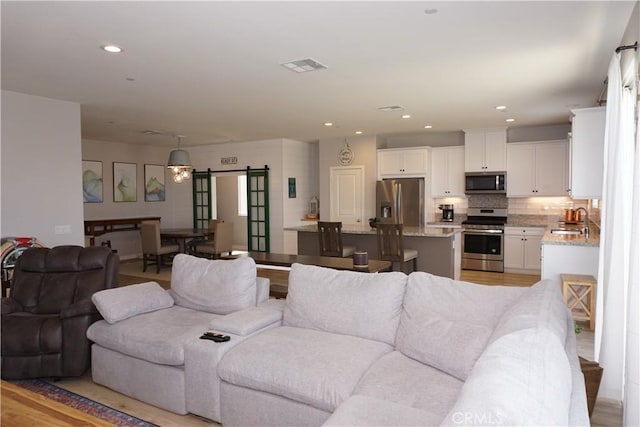 34539 Velvetleaf St, Winchester, CA 92596 - living room featuring a barn door and recessed lighting