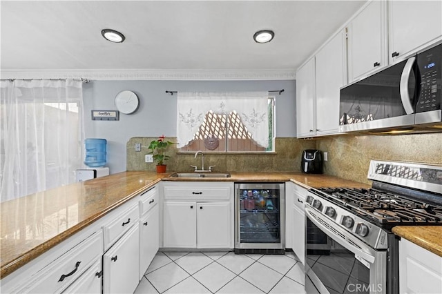 kitchen featuring a sink, wine cooler, stainless steel appliances, and plenty of natural light