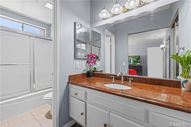 bathroom featuring tile patterned floors, toilet, vanity, and shower / tub combination