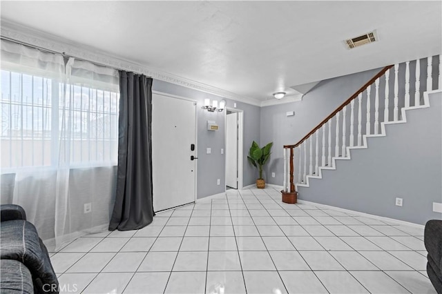 foyer with stairway, ornamental molding, light tile patterned flooring, and visible vents