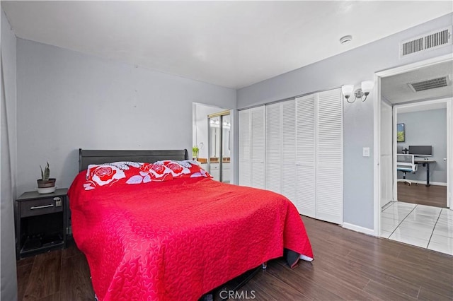 bedroom with visible vents, wood finished floors, and baseboards