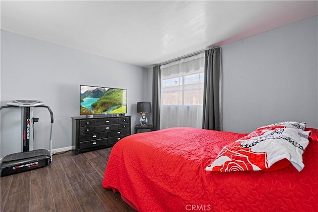 bedroom featuring baseboards and dark wood-style floors