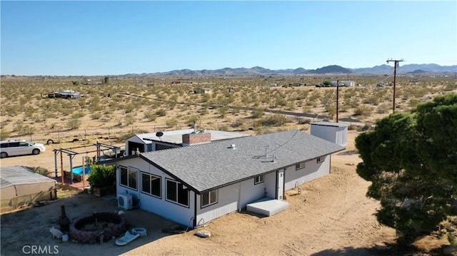 drone / aerial view with a mountain view, a rural view, and view of desert