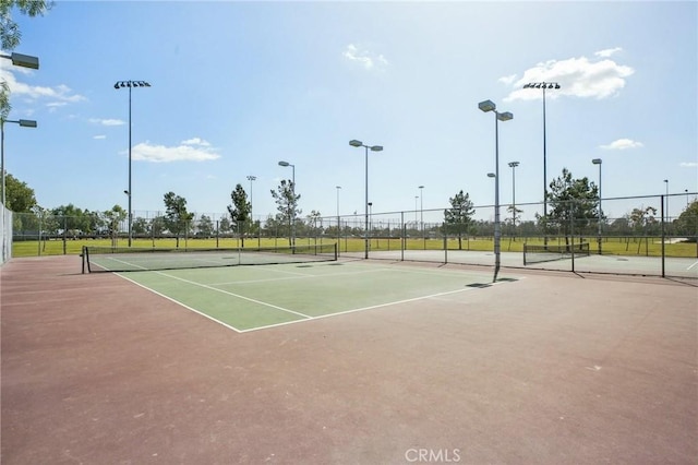 view of tennis court with community basketball court and fence