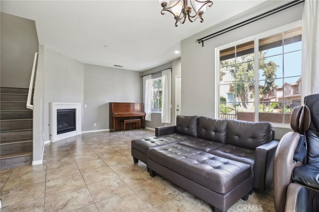 living room with a fireplace, visible vents, stairway, a notable chandelier, and baseboards