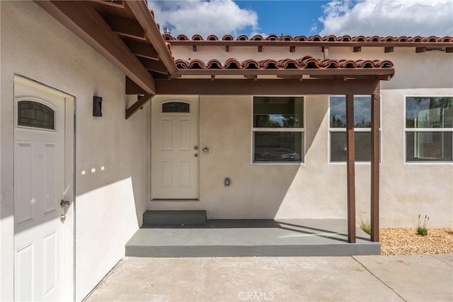 doorway to property featuring stucco siding