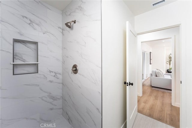 bathroom featuring a marble finish shower, visible vents, and wood finished floors