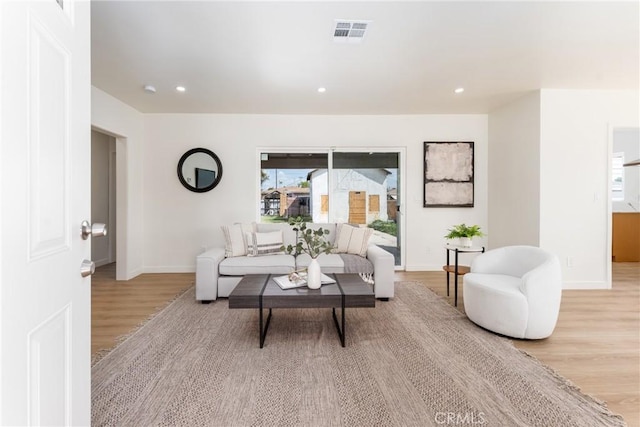 living area with recessed lighting, baseboards, light wood finished floors, and visible vents
