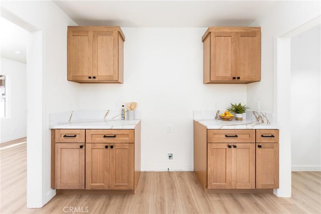 interior space featuring light wood finished floors, baseboards, and light countertops