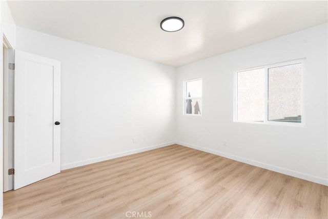 empty room with baseboards and light wood-style floors