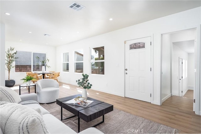 living room featuring light wood-style flooring, recessed lighting, baseboards, and visible vents