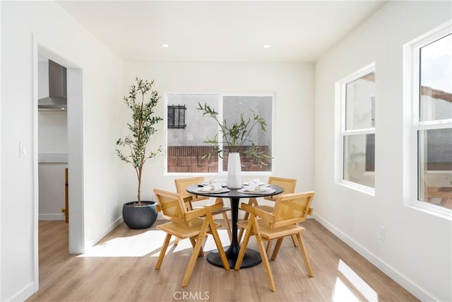dining space with baseboards, light wood-type flooring, and recessed lighting