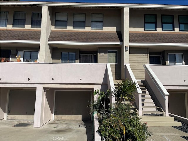 2168 Biscayne, Costa Mesa, CA 92627 - view of front of house featuring stairs, stucco siding, an attached garage, driveway, and roof with shingles