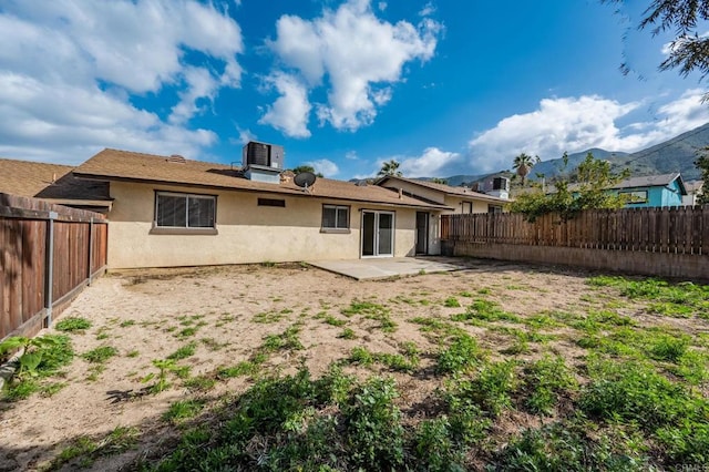 back of property featuring a fenced backyard, stucco siding, a patio, and central AC unit