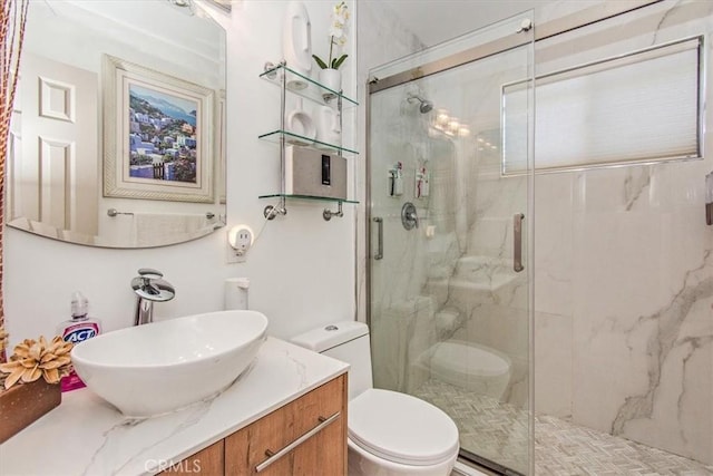 bathroom featuring toilet, vanity, and a marble finish shower