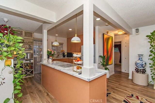 interior space featuring wood finished floors, freestanding refrigerator, and a textured ceiling