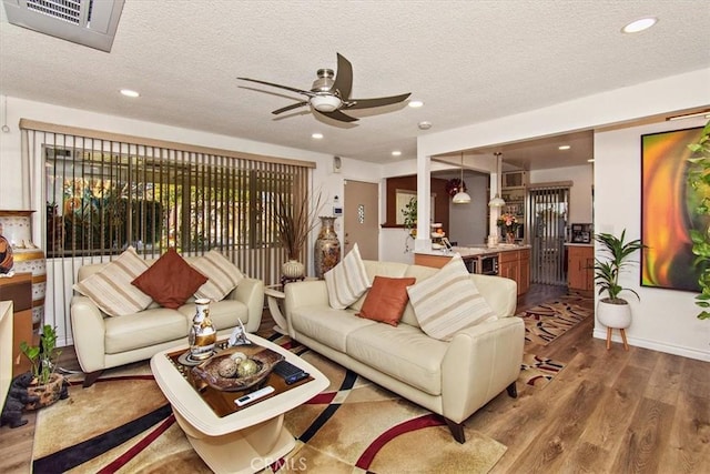 living room featuring visible vents, a ceiling fan, wood finished floors, and recessed lighting