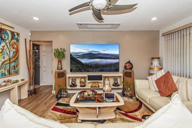 living area with recessed lighting, wood finished floors, a textured ceiling, and a ceiling fan