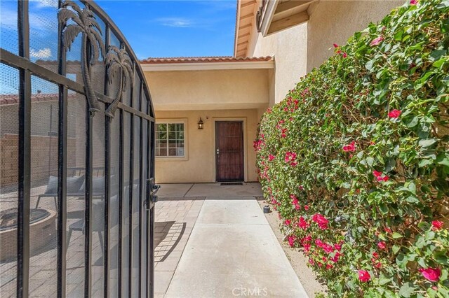 43475 Brahea Ct, Indio, CA 92201 - doorway to property with stucco siding and a tiled roof