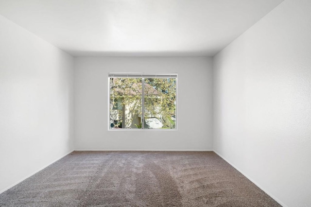 unfurnished room featuring carpet flooring and baseboards