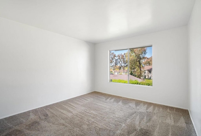 carpeted empty room with baseboards