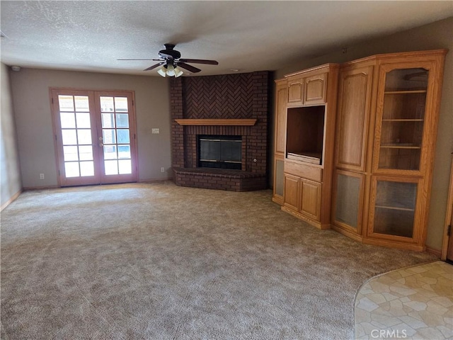 unfurnished living room featuring baseboards, a ceiling fan, a brick fireplace, and light colored carpet