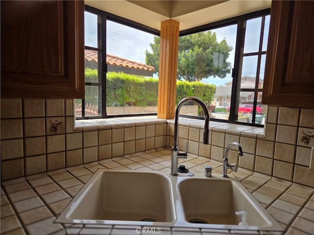 details with tile countertops, a sink, and tasteful backsplash
