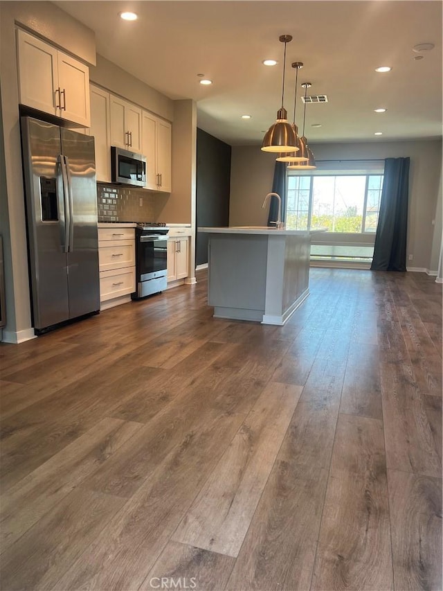 kitchen featuring stainless steel appliances, decorative backsplash, recessed lighting, and dark wood-style flooring