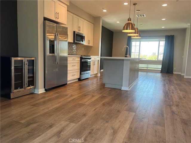 kitchen with backsplash, appliances with stainless steel finishes, recessed lighting, and wine cooler