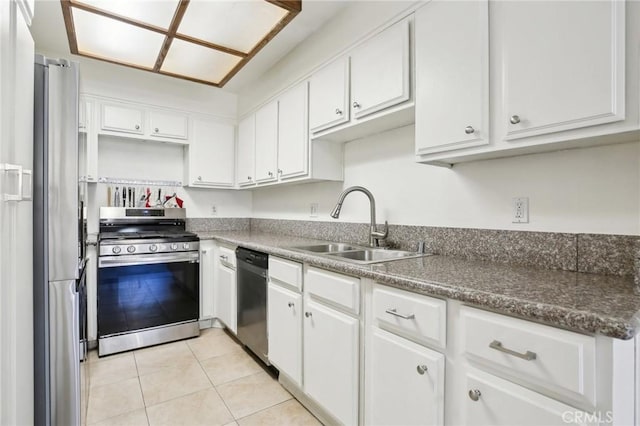 kitchen featuring appliances with stainless steel finishes, a sink, white cabinetry, and light tile patterned floors